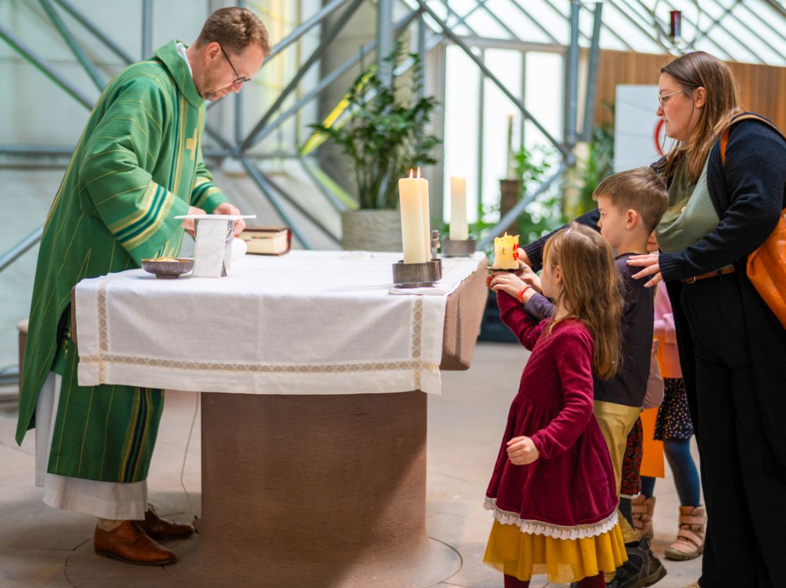 Kinder gehen zum Altar in der Homebase mit einer Kerze